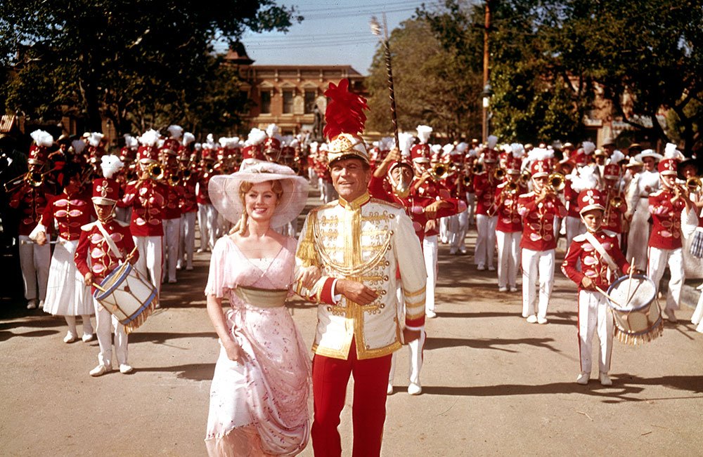 Robert Preston y Shirley Jones acompañados de una colosal banda militar en una de las escenas centrales de The Music Man (conocida en Latinoamérica como "Vivir de Ilusión")