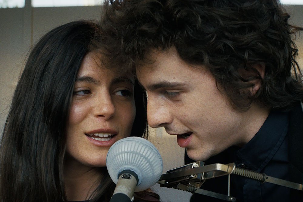Joan Báez (Monica Barbaro) y Bob Dylan (Thimothée Chalamet) cantando juntos en Un Completo Desconocido.